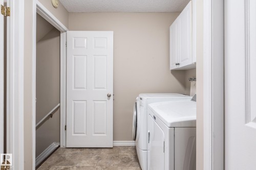 Laundry area featuring tile-finish flooring and light beige wall paint - 16811 91 Street, Edmonton, AB 