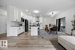 Open-concept living space with wood-finish flooring - 