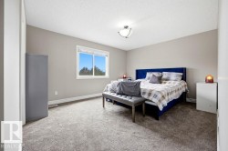Spacious room featuring neutral painted walls, textured carpet, and a large window providing ample natural light - 