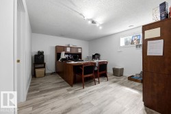 Spacious room featuring light-toned wood-finish flooring, white walls, and a window providing natural light - 