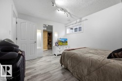 Room featuring light wood-finish flooring, white walls, and a window with white trim - 