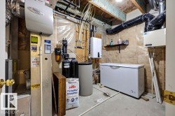 Utility room featuring exposed ceiling joists, concrete flooring, and various mechanical systems - 