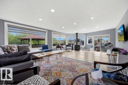 Spacious living area featuring wood-finish flooring, recessed lighting, and a freestanding stove - 