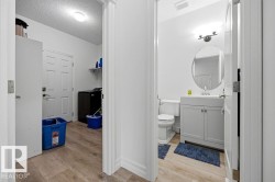 Hallway with wood-finish flooring providing access to two distinct areas - 
