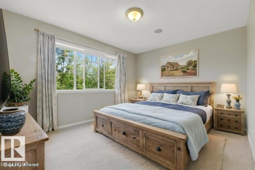 Newly carpeted room featuring a large window with multiple panes, light-colored walls, and a ceiling-mounted light fixture Virtually staged - 12215 18 Avenue Sw, Edmonton, AB 