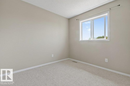 Neutral-toned walls complement the light-colored carpet flooring - 12215 18 Avenue Sw, Edmonton, AB 