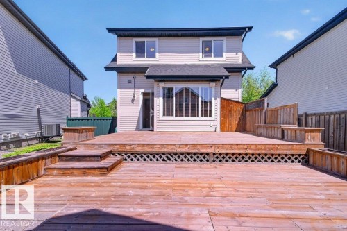 Multi-level wooden deck featuring lattice skirting and built-in planters - 12215 18 Avenue Sw, Edmonton, AB 