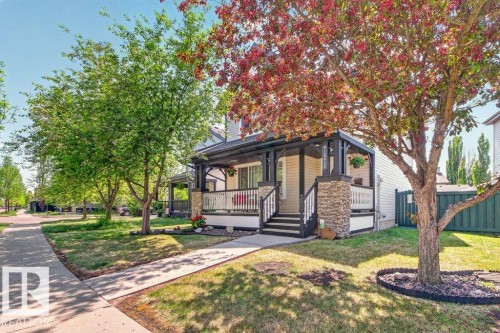 Exterior featuring a covered front porch with stone accents and white railings - 12215 18 Avenue Sw, Edmonton, AB 