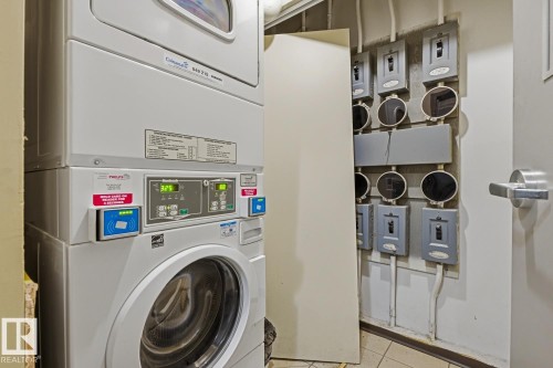 Commercial-grade stacked washer and dryer unit, featuring digital displays and card-reader payment systems - 703 9710 105 Street, Edmonton, AB 