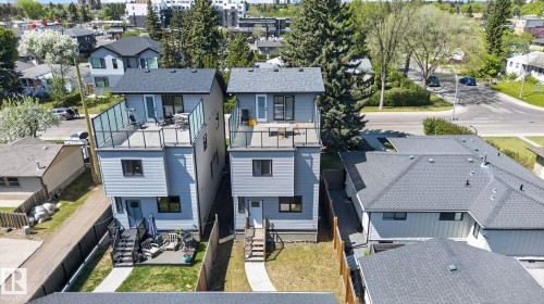 Contemporary duplex exteriors featuring light gray siding and dark gray roofing - 8809 148 Street, Edmonton, AB - Outdoor With Deck Patio Veranda With Facade
