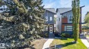 Contemporary exterior featuring a distinctive sloped roofline, dark-framed windows, and a mix of grey siding with brown accent panels - 8809 148 Street, Edmonton, AB  - Outdoor With Facade 