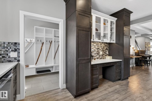 Built-in cabinetry with glass-front uppers, a functional desk area, and a mosaic tile backsplash - 8809 148 Street, Edmonton, AB - Indoor