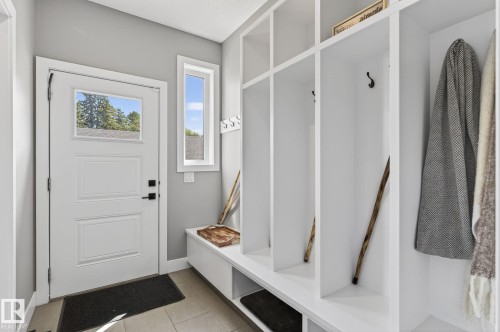 Entryway featuring a white paneled door with integrated window, an adjacent vertical window, and built-in storage cubbies - 8809 148 Street, Edmonton, AB - Indoor Photo Showing Other Room