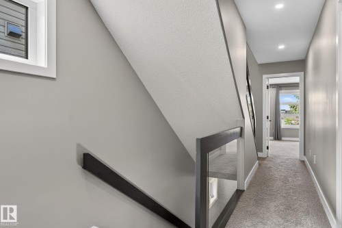 Stairwell featuring a dark wood-finish handrail and glass paneling - 8809 148 Street, Edmonton, AB - Indoor Photo Showing Other Room