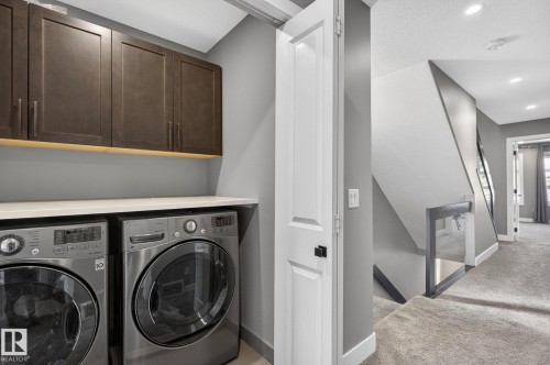 Dedicated laundry area featuring a white countertop and wood-finish upper cabinetry - 8809 148 Street, Edmonton, AB - Indoor Photo Showing Laundry Room