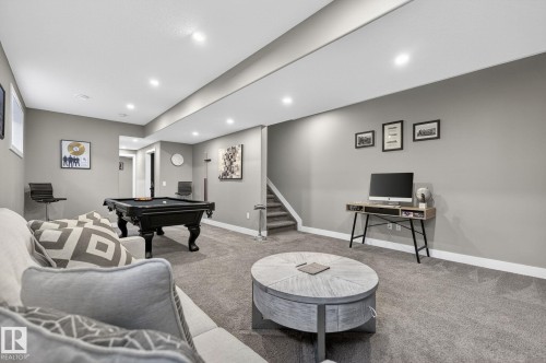 Expansive recreation area featuring recessed lighting, gray carpeting, white trim, and a staircase with a carpeted runner - 8809 148 Street, Edmonton, AB - Indoor