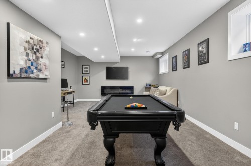 Recreation room featuring a pool table, wall-mounted television, built-in linear fireplace, recessed lighting, and light gray walls with white baseboards - 8809 148 Street, Edmonton, AB - Indoor Photo Showing Other Room