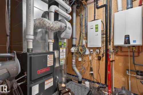 Mechanical room featuring a Goodman furnace, a whole-house humidifier, a tankless water heater, and a primary electrical panel - 8809 148 Street, Edmonton, AB - Indoor Photo Showing Basement