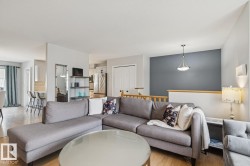 Hardwood-finish flooring throughout, featuring a kitchen with a stainless steel refrigerator and built-in cabinetry, and a dining area with a breakfast bar - 