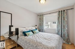 Bright bedroom featuring a single window, a ceiling-mounted light fixture, and wood-finish flooring - 