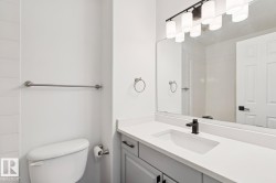 Bathroom vanity featuring a matte black single-handle faucet, integrated rectangular sink, and light-toned countertop - 