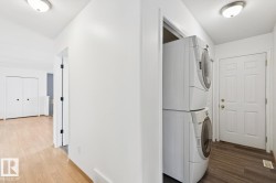 Dedicated laundry area featuring a stacked washer and dryer unit - 