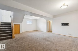 Open concept room with neutral carpeting, white walls, and a window for natural light - 