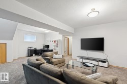 Carpeted room with a wall-mounted television and a built-in ceiling light fixture - 