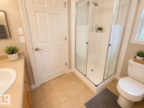 Corner shower with clear glass enclosure and chrome fixtures - 102 Hartwick Loop, Spruce Grove, AB 