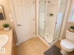 Corner shower with clear glass enclosure and chrome fixtures - 