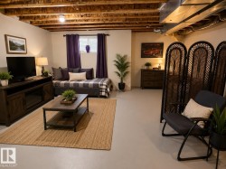 Finished basement space featuring exposed ceiling joists and ductwork - 