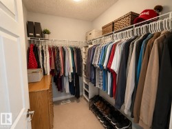 Walk-in closet featuring wire shelving, integrated hanging rods, and neutral carpet flooring - 