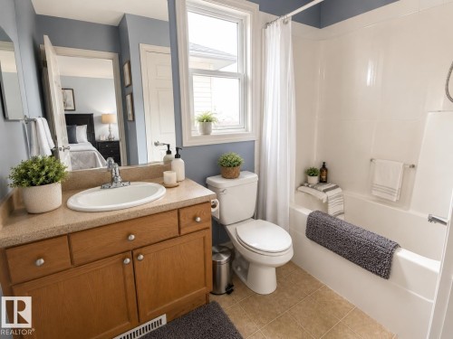 Bathroom with light wood-finish vanity, oval undermount sink, and light speckled countertop - 102 Hartwick Loop, Spruce Grove, AB 