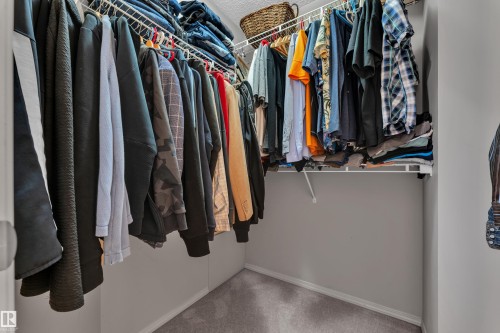 Walk-in closet with carpet flooring, white wire shelving, and hanging rods - 14031 136 Street, Edmonton, AB 