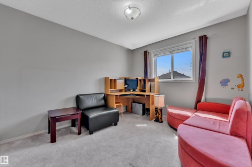 Carpeted room featuring a window with blinds, a light grey painted wall, and a ceiling-mounted light fixture - 14031 136 Street, Edmonton, AB 