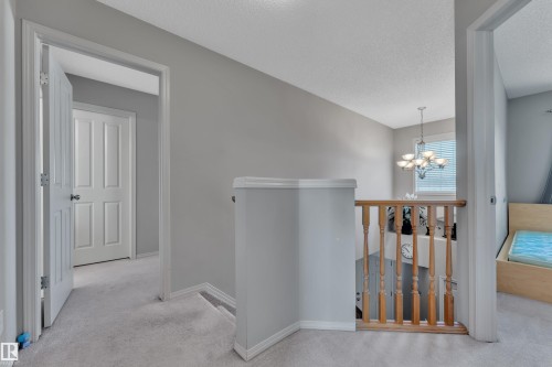 Upper-level hallway featuring light gray walls, plush carpeting, and white panel doors - 14031 136 Street, Edmonton, AB 