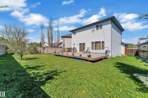 Expansive backyard featuring a wood deck, sliding glass door access, horizontal siding exterior, and a privacy fence - 14031 136 Street, Edmonton, AB 