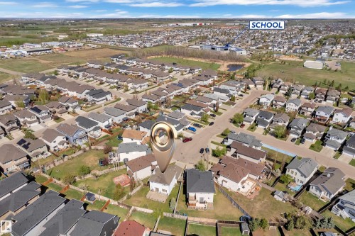 Aerial perspective showcasing a residential neighborhood with a prominent school building in the background - 14031 136 Street, Edmonton, AB 