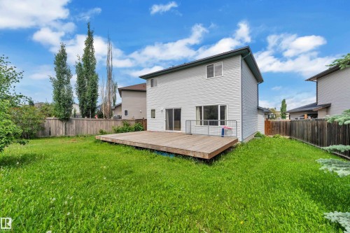 Expansive backyard featuring a large wood deck, mature trees, and privacy fencing - 14031 136 Street, Edmonton, AB 
