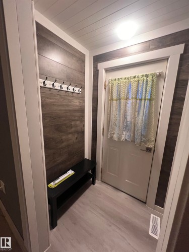 Entryway featuring wood-finish wall panels and wood-finish flooring - 69 Railway Avenue, Star, AB 