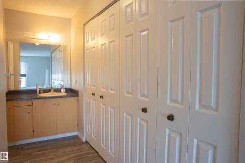 Expansive white paneled closet doors with brass hardware - 1703 11027 87 Avenue N, Edmonton, AB - Indoor Photo Showing Other Room