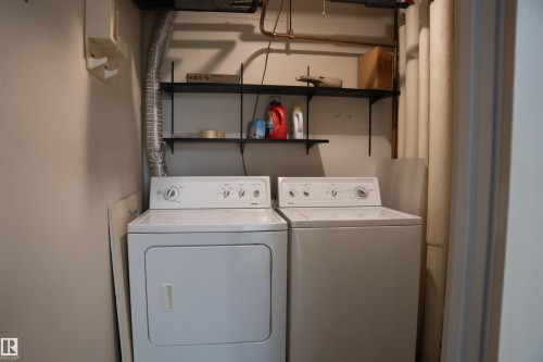 Dedicated laundry area featuring a washer and dryer, along with wall-mounted shelving for organization - 1703 11027 87 Avenue N, Edmonton, AB - Indoor Photo Showing Laundry Room