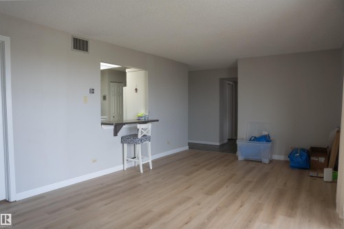 Spacious room featuring wood-finish flooring, light grey wall paint, and white baseboards - 1703 11027 87 Avenue N, Edmonton, AB - Indoor Photo Showing Other Room