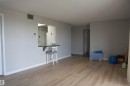 Spacious room featuring wood-finish flooring, light grey wall paint, and white baseboards - 1703 11027 87 Avenue N, Edmonton, AB  - Indoor Photo Showing Other Room 