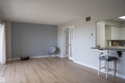 Spacious living area featuring light wood-finish flooring, a neutral color palette, and French doors - 