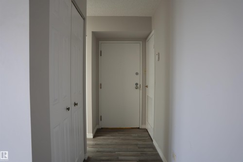 Entryway featuring wood-finish flooring, white walls, and a textured ceiling - 1703 11027 87 Avenue N, Edmonton, AB - Indoor Photo Showing Other Room