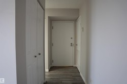 Entryway featuring wood-finish flooring, white walls, and a textured ceiling - 
