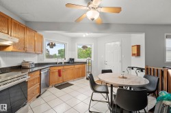 Kitchen featuring wood cabinetry, dark countertops, white tile backsplash, and stainless steel appliances including a range and dishwasher - 