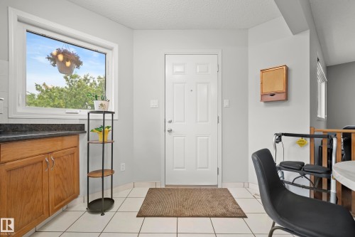 Entry area with white tiled flooring and a paneled entry door - 15503 62 Street, Edmonton, AB 