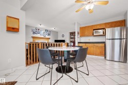 Kitchen area featuring white tiled flooring and a ceiling fan - 